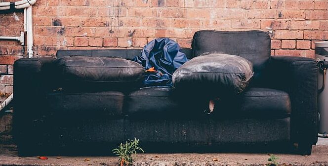 black-3-seat-sofa-beside-brick-wall-e1586791567806.jpg