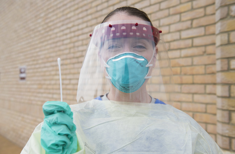 Nurse with face shield and COVID swab