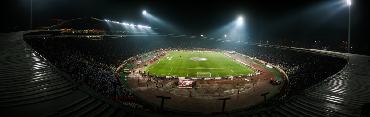 Large soccer stadium filled with fans at night